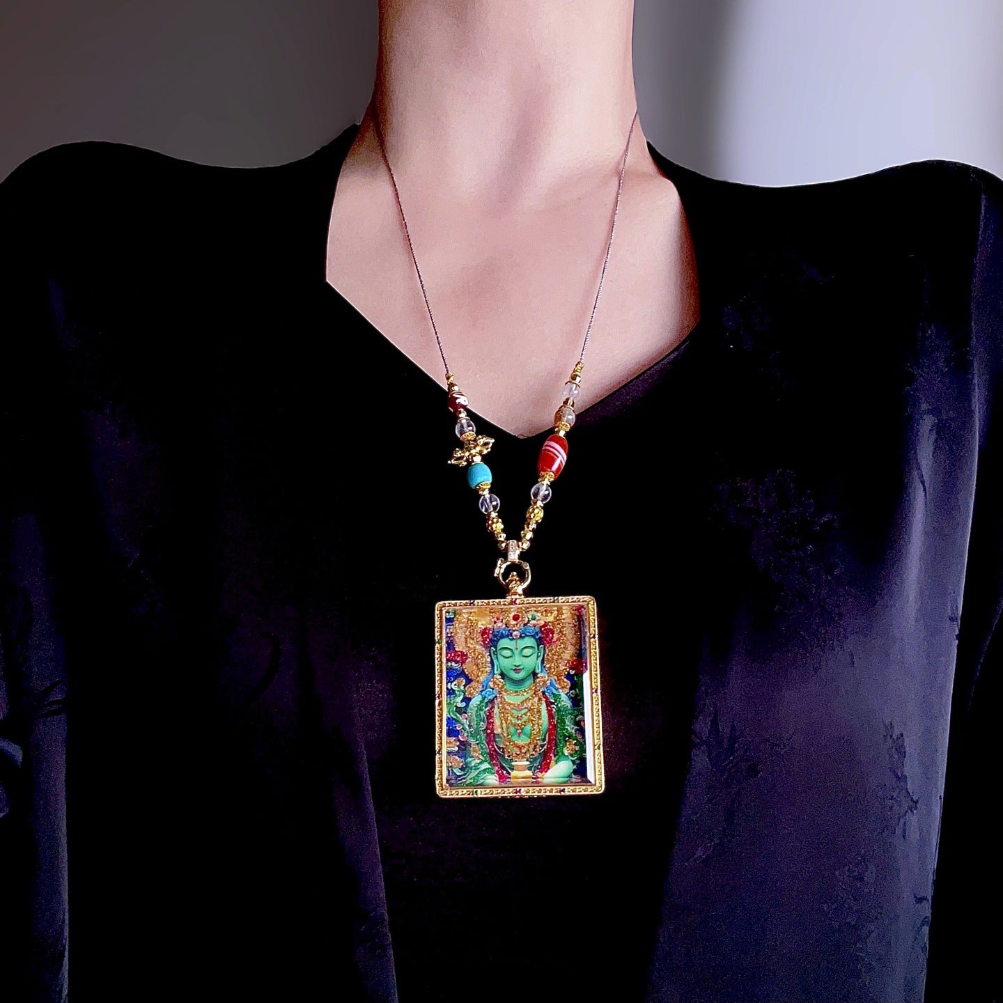 Green Tara pendant worn as Buddhist spiritual amulet