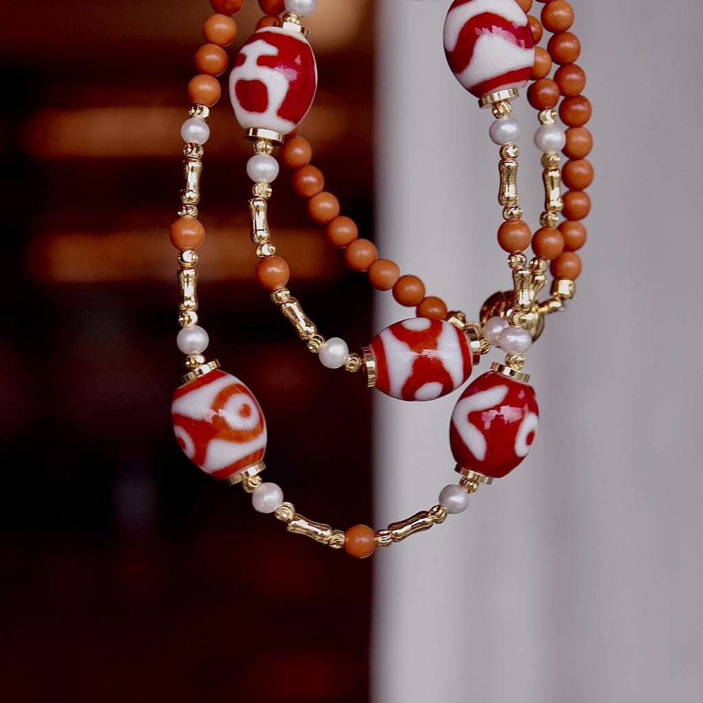 Close-up of hand-painted red & white dzi bead texture on Aurafeng necklace