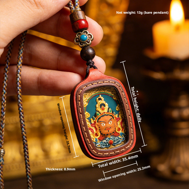 Hand holding Tibetan gau box pendant with detailed hand-painted thangka artwork