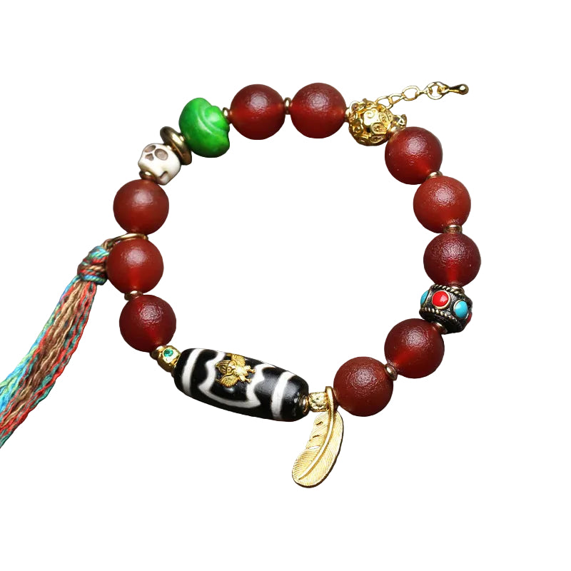 Detailed view of Tibetan dzi bead and vintage bone-style accents on the red agate bracelet