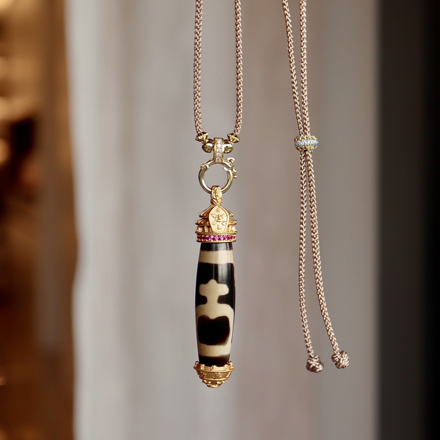 Handmade Tibetan dzi bead pendant worn as Buddhist protection amulet