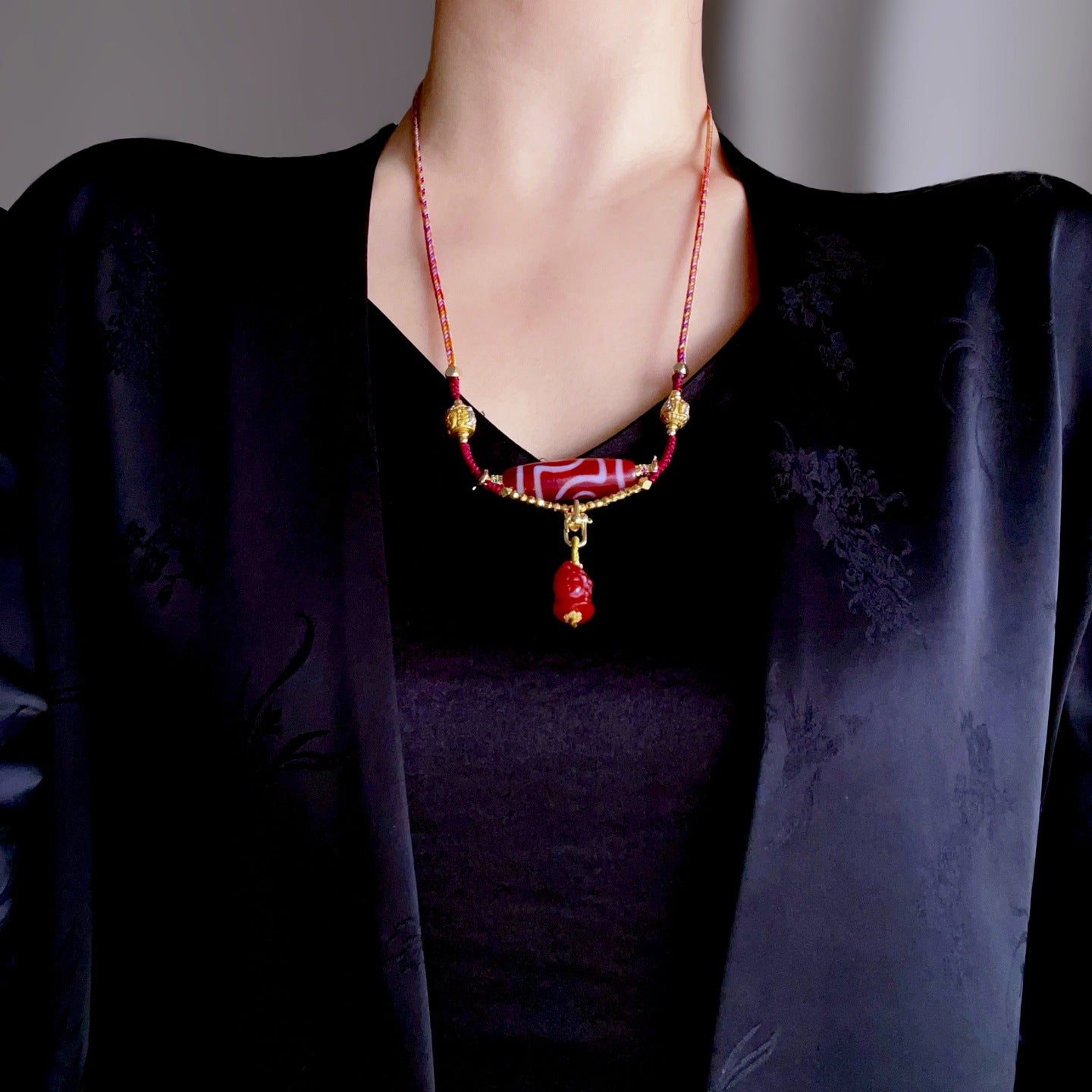 Two eyed Tibetan dzi bead pendant symbolizing wealth and protection