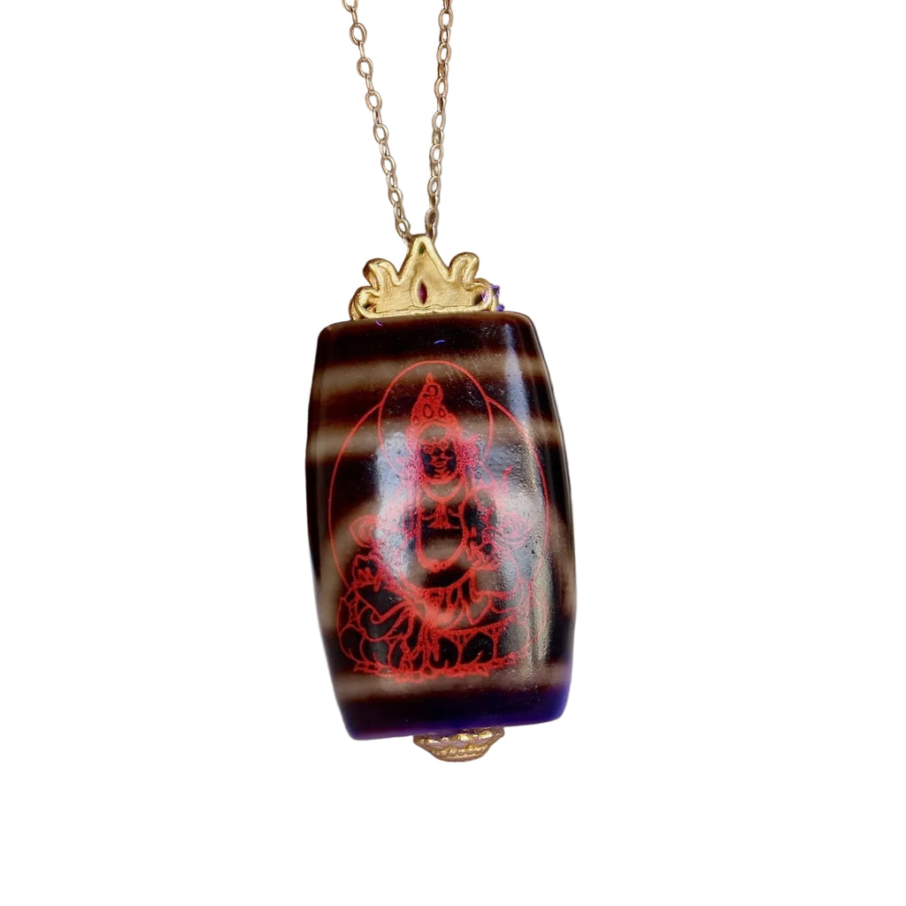 Two eyed Tibetan dzi bead pendant symbolizing wealth and protection