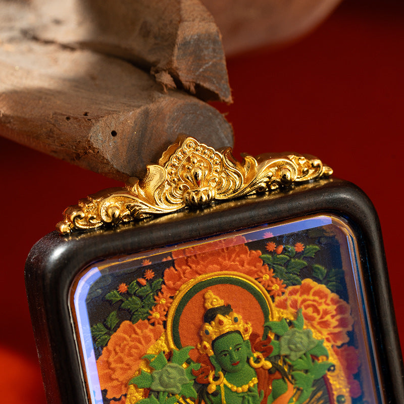 Close-up of hand-painted thangka artwork on wooden gau box pendant